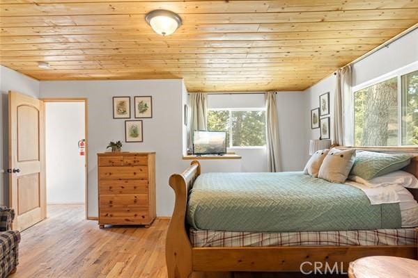 bedroom featuring light hardwood / wood-style flooring, multiple windows, and wooden ceiling