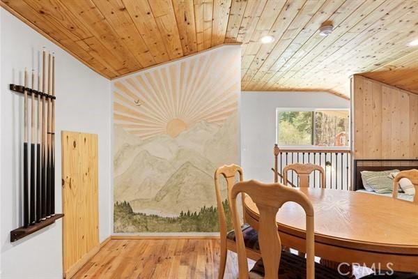 dining area featuring hardwood / wood-style flooring, vaulted ceiling, wood walls, and wood ceiling