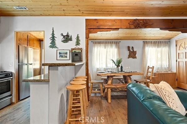 interior space with light hardwood / wood-style floors, a healthy amount of sunlight, and wooden ceiling