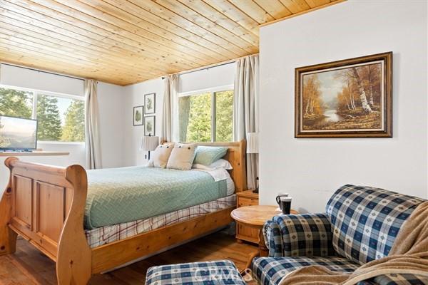 33544 Green Valley Lake Rd, Green Valley Lake, CA 92341 - bedroom with multiple windows, wooden ceiling, and wood finished floors