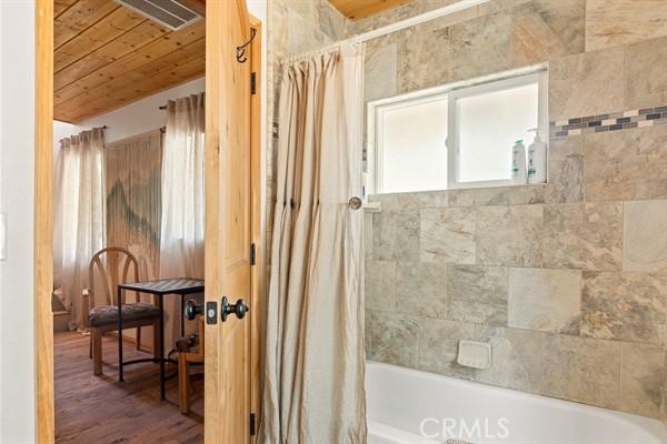 33544 Green Valley Lake Rd, Green Valley Lake, CA 92341 - full bath featuring shower / tub combo with curtain, wooden ceiling, and wood finished floors