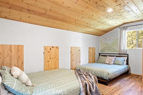 bedroom with hardwood / wood-style floors, lofted ceiling, and wood ceiling