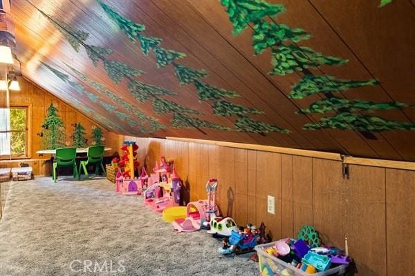 rec room featuring carpet flooring, wooden walls, wood ceiling, and vaulted ceiling