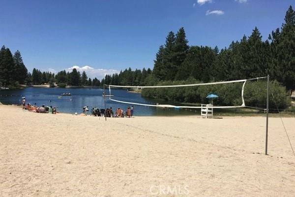 view of property's community with volleyball court and a water view