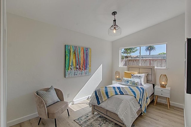 bedroom featuring light hardwood / wood-style floors and vaulted ceiling