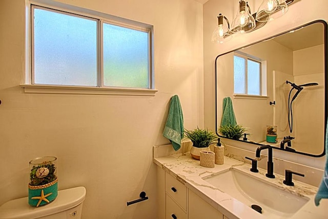 bathroom featuring vanity, toilet, and an inviting chandelier