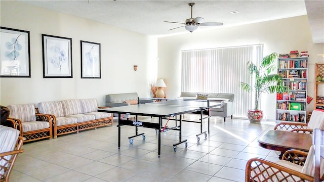 game room featuring ceiling fan, light tile patterned floors, and a textured ceiling