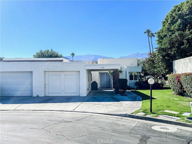 view of front of house featuring a mountain view, a garage, and a front lawn