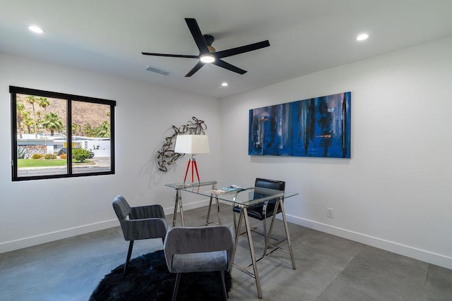 dining space with ceiling fan and concrete flooring