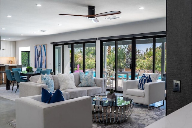 living room with ceiling fan and concrete floors