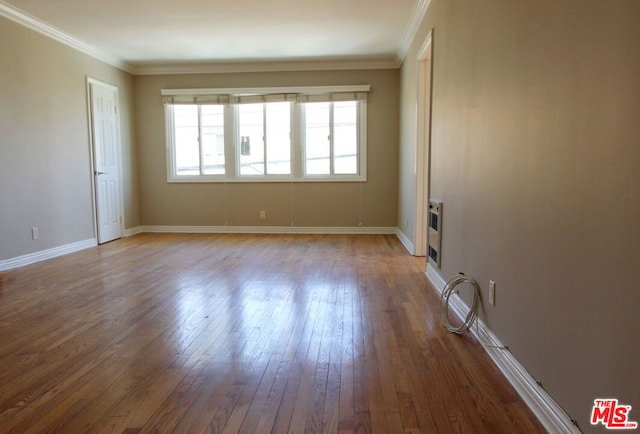 empty room with dark hardwood / wood-style flooring and ornamental molding