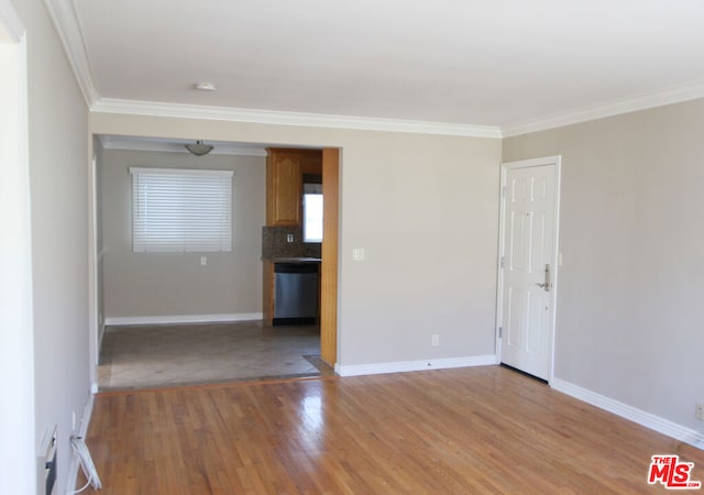 spare room with ornamental molding and light hardwood / wood-style flooring