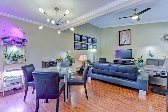 dining room with ceiling fan with notable chandelier, hardwood / wood-style flooring, and crown molding