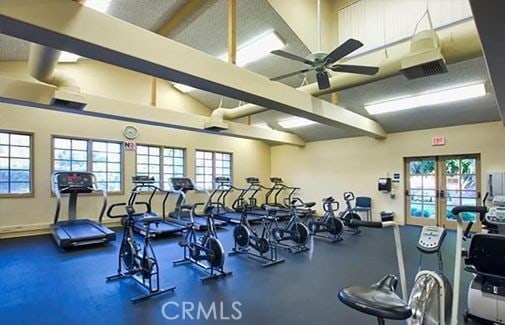 workout area featuring french doors, ceiling fan, vaulted ceiling, and plenty of natural light