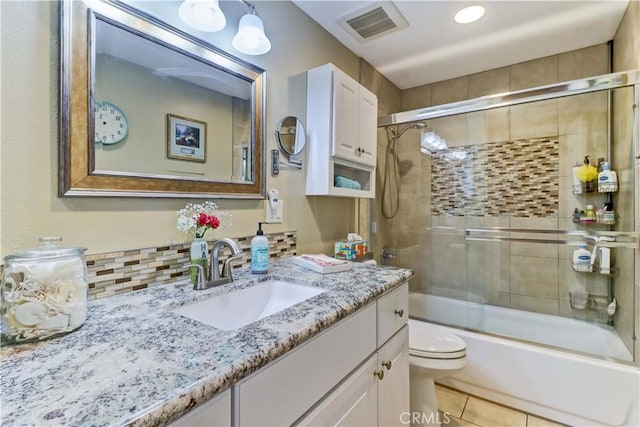 full bathroom with toilet, tile patterned flooring, vanity, and bath / shower combo with glass door