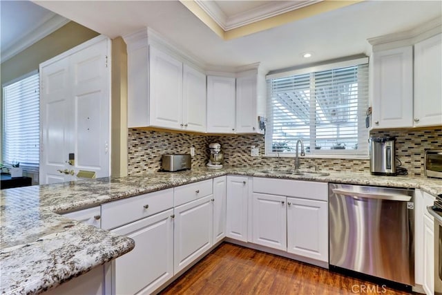 kitchen featuring sink, stainless steel appliances, white cabinetry, and decorative backsplash