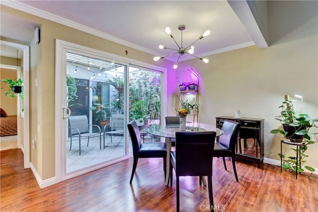 dining room with a chandelier, ornamental molding, and hardwood / wood-style flooring