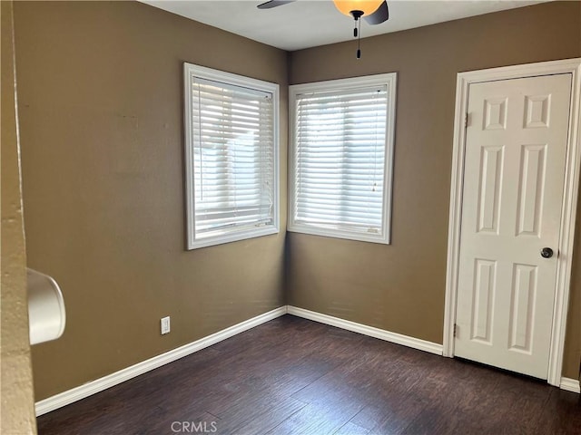 empty room featuring ceiling fan and dark hardwood / wood-style flooring