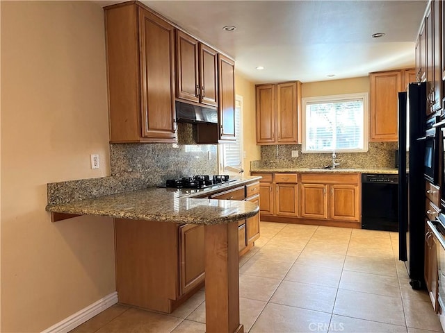 kitchen featuring light tile patterned flooring, backsplash, light stone counters, and black appliances