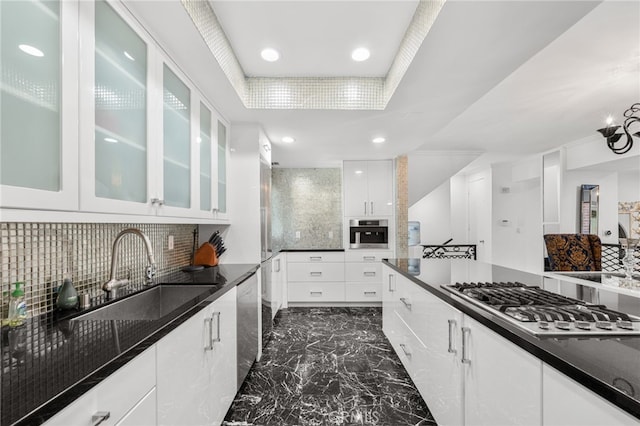 kitchen with backsplash, white cabinets, sink, dark stone countertops, and stainless steel appliances