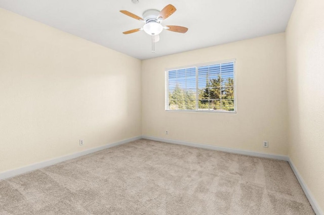 carpeted spare room with ceiling fan