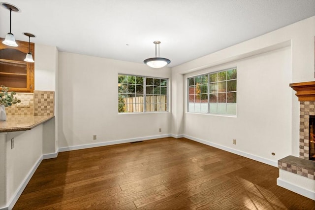 unfurnished living room with dark hardwood / wood-style floors and a brick fireplace