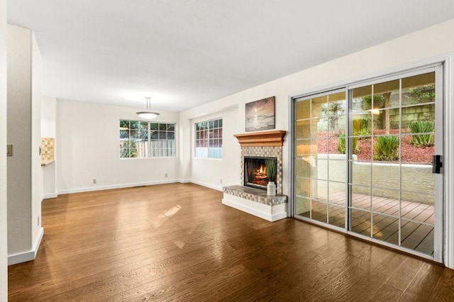 unfurnished living room with hardwood / wood-style floors and a brick fireplace