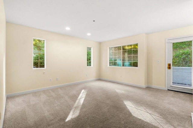 unfurnished room with a healthy amount of sunlight and light colored carpet