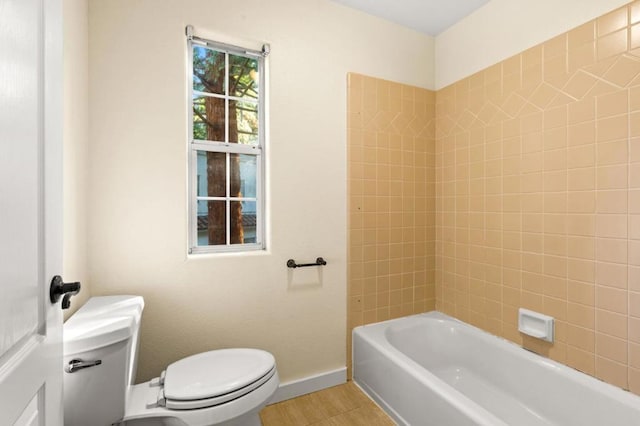 bathroom featuring tiled shower / bath, wood-type flooring, and toilet