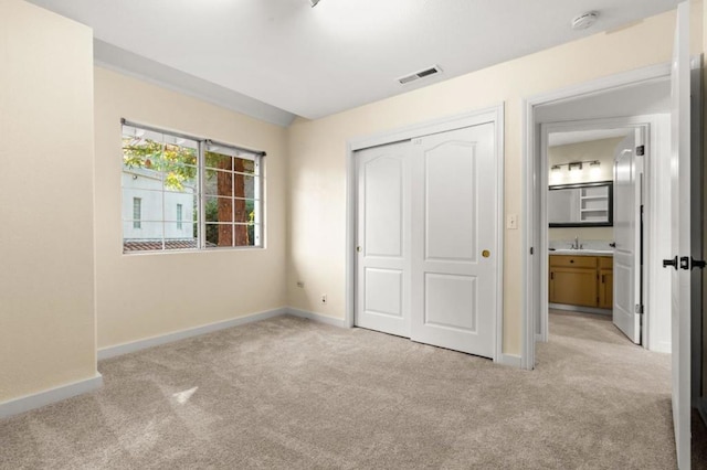 unfurnished bedroom with light carpet and a closet