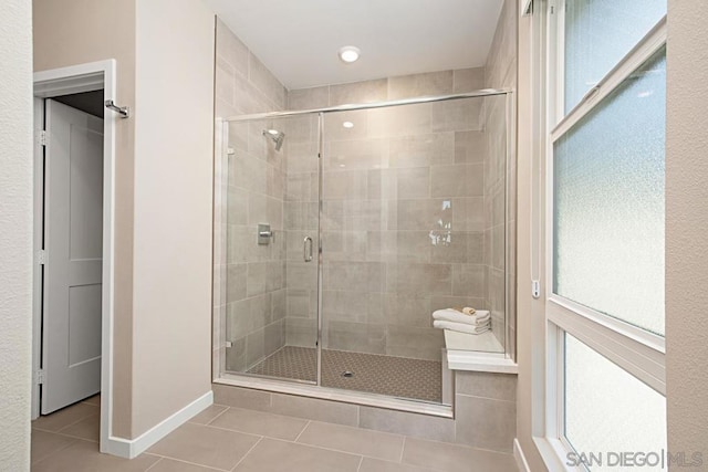 bathroom with an enclosed shower and tile patterned flooring