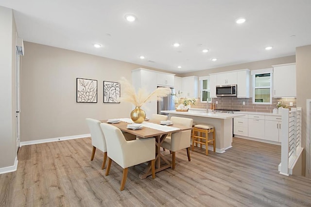 dining space with sink and light hardwood / wood-style floors