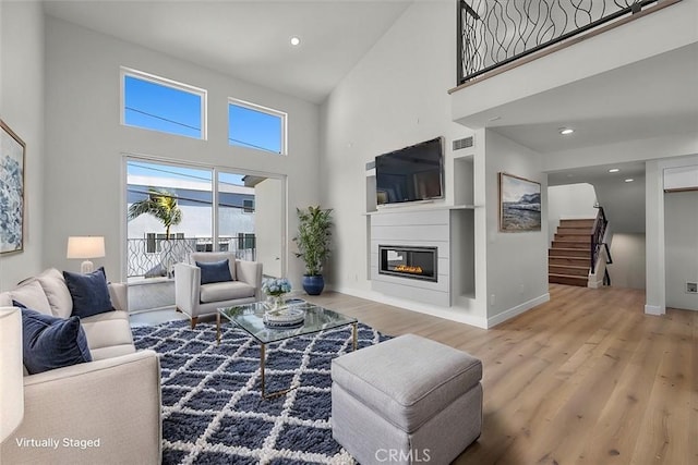 living room featuring a high ceiling and wood-type flooring