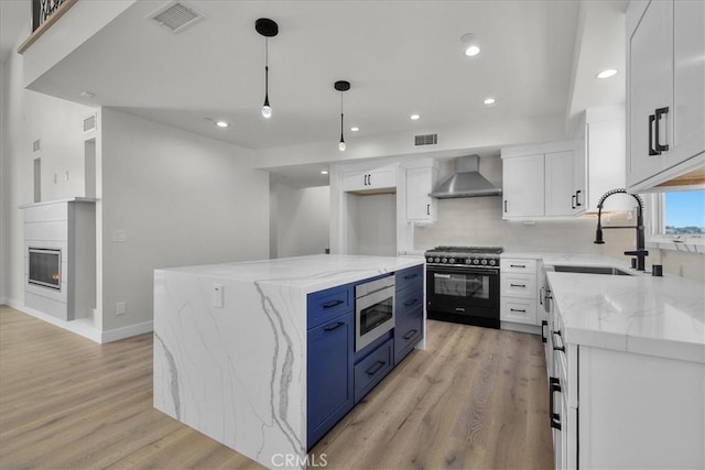 kitchen featuring white cabinets, a center island, and high end black range