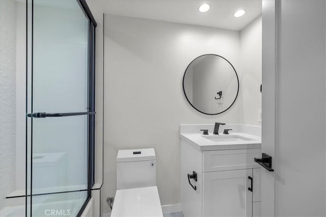 bathroom with vanity, toilet, and a shower with door