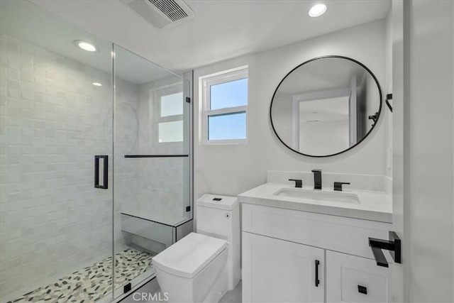 bathroom with vanity, toilet, and a shower with shower door