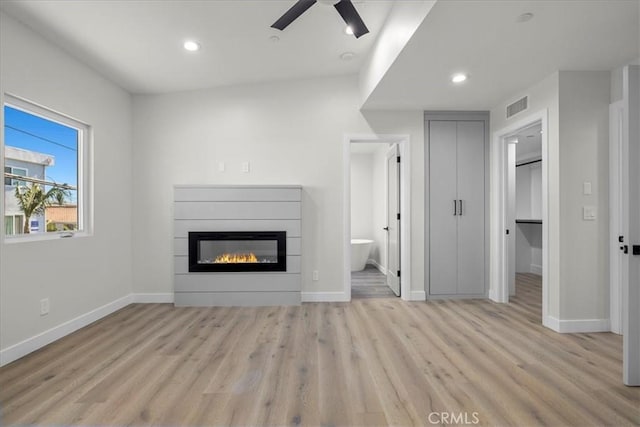 unfurnished living room featuring ceiling fan and light hardwood / wood-style floors