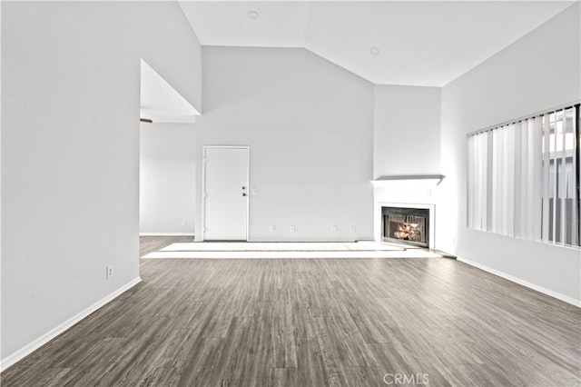 unfurnished living room featuring dark hardwood / wood-style flooring and high vaulted ceiling