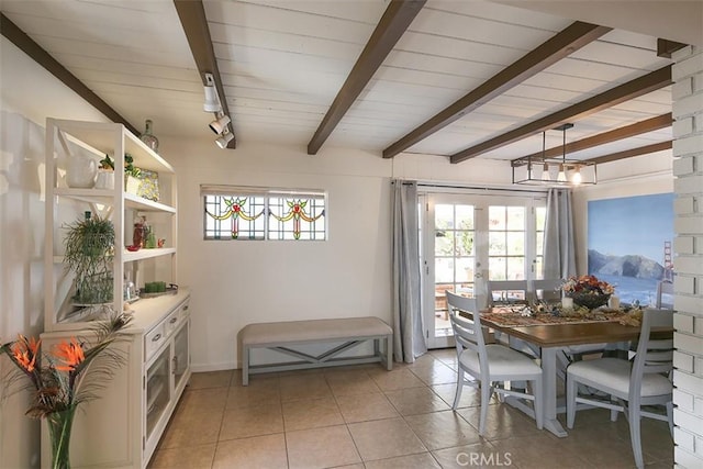 dining space featuring beamed ceiling, plenty of natural light, and light tile patterned flooring