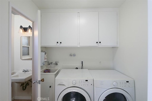 laundry room with cabinets, washer and dryer, and sink