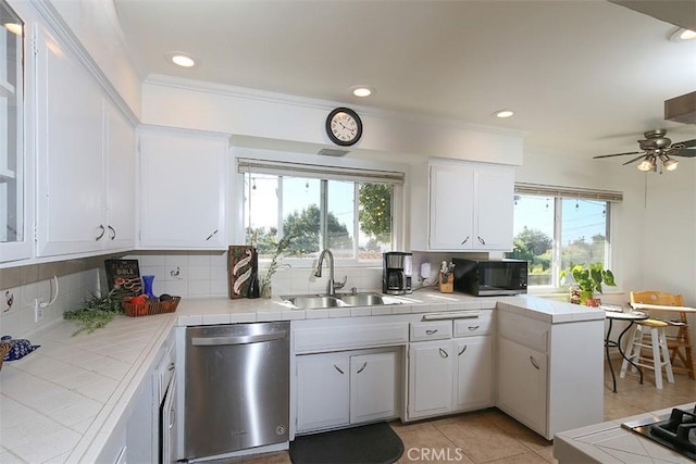 kitchen featuring dishwasher, tile counters, white cabinets, and sink