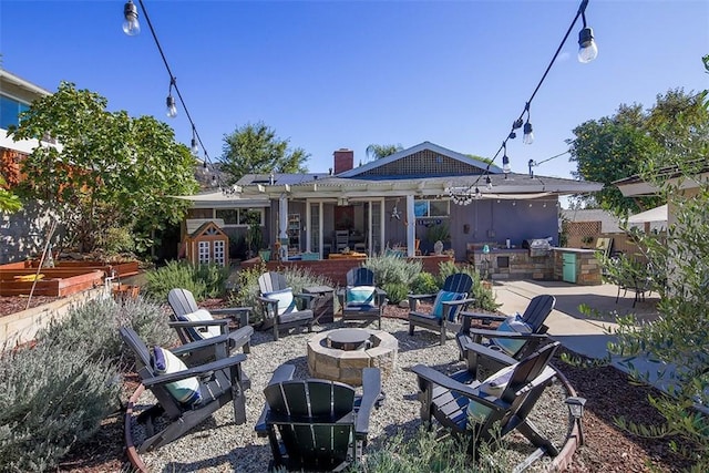 back of house featuring a fire pit and a patio