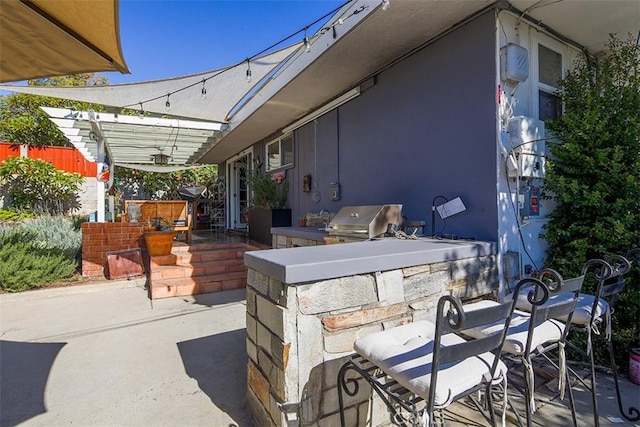 view of patio featuring a bar, area for grilling, and exterior kitchen