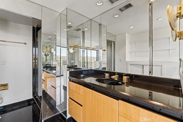 bathroom with tile patterned floors, vanity, and a shower with door