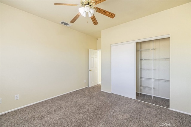 unfurnished bedroom featuring ceiling fan, dark carpet, and a closet