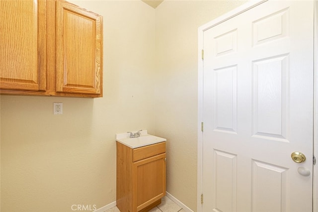 laundry room featuring light tile patterned floors and sink