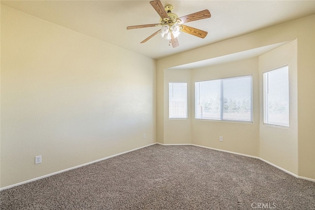 unfurnished room with ceiling fan and carpet