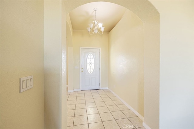 doorway to outside with a chandelier and light tile patterned flooring