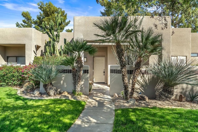 pueblo revival-style home featuring a front yard and cooling unit