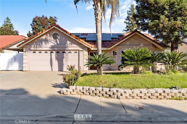 ranch-style house featuring a garage and solar panels